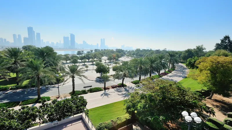 Landscaped community park with palm trees and residential towers in the UAE